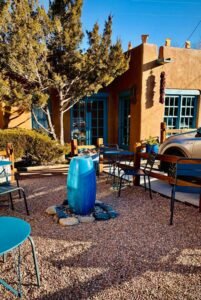 Patio area with blue pots and adobe buildings.